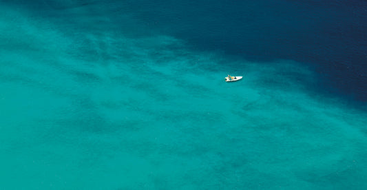 A Boat Floats In The Sea Off The Coast Of Italy