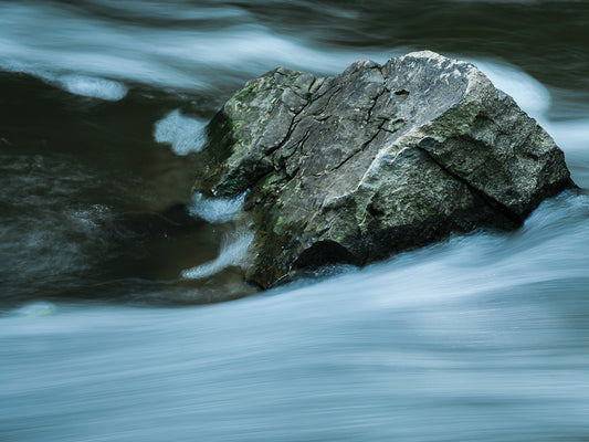 Large Jagged Boulder In Slow Flowing Water Canvas Art