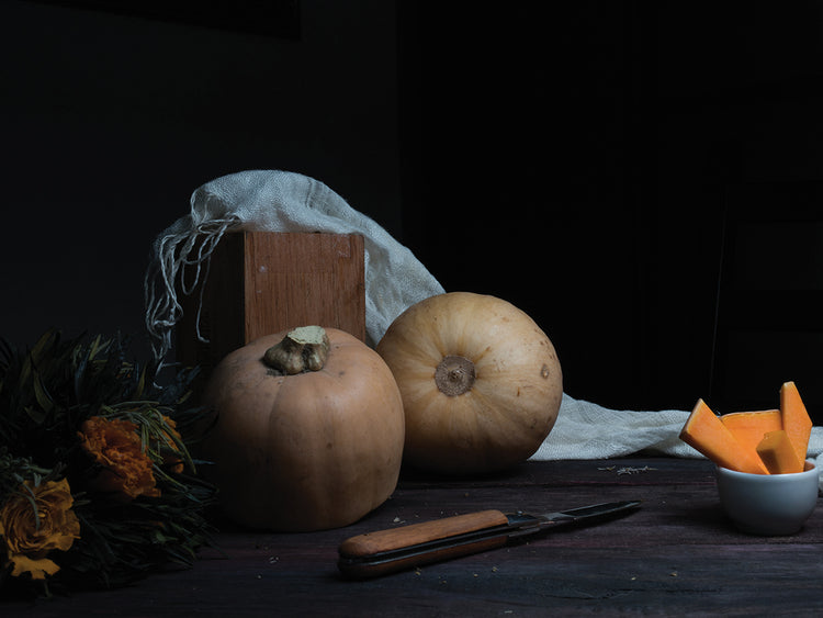 pumpkin and orange roses on a dark wooden table