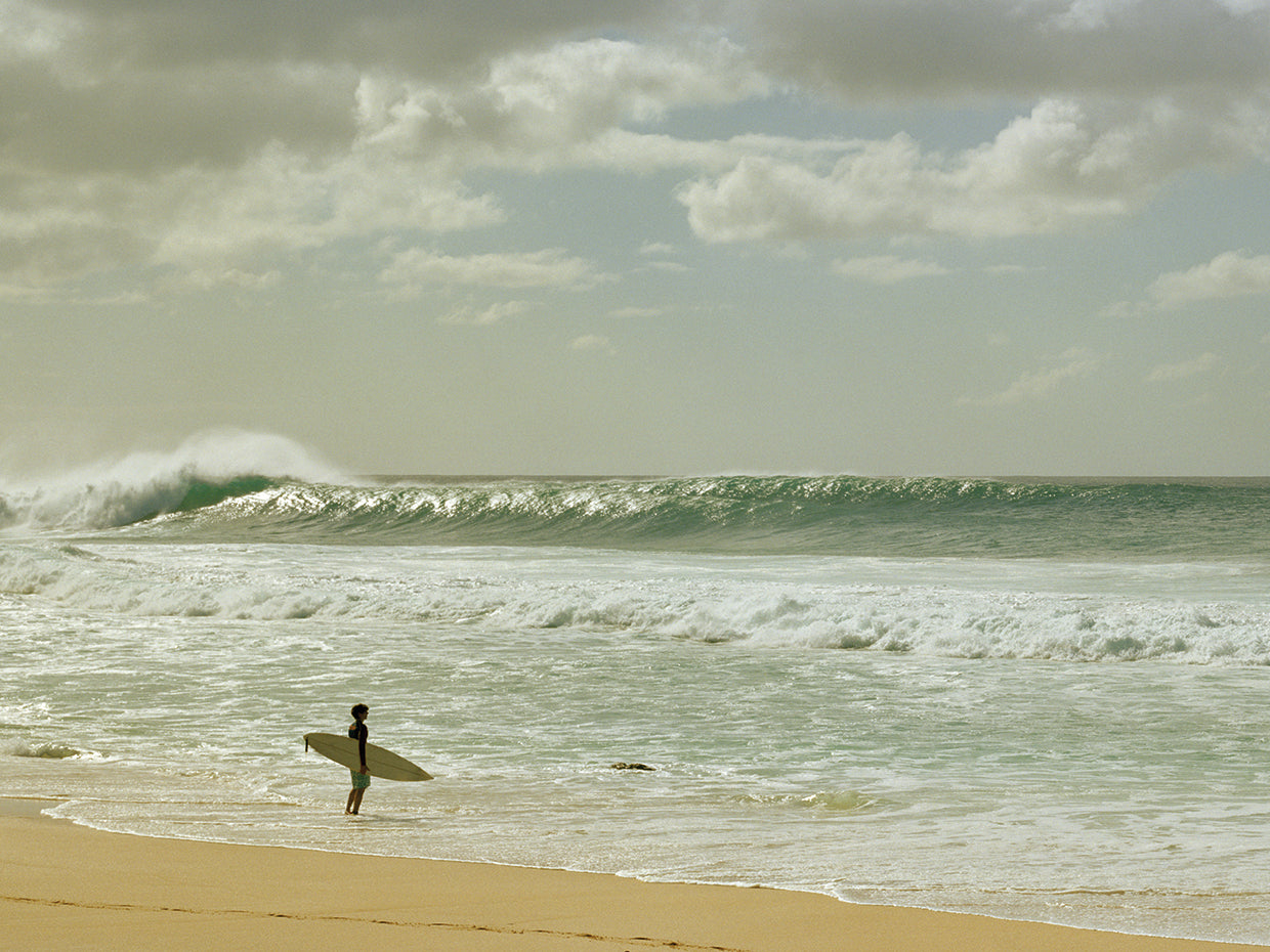 Surfer standing on the beach, North Shore, Oahu,Hawaii,USA